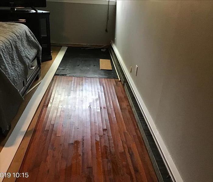 hardwood flooring warped from standing water in a bedroom